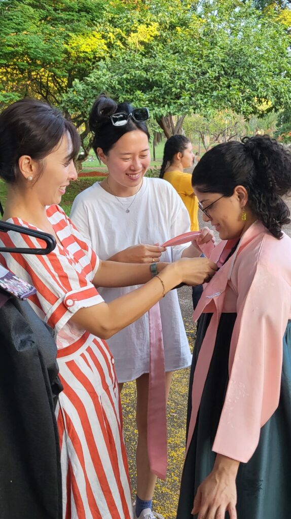 2023-11 - Chorong Lee e Wongyeong Yun ajudando aluna a vestir hanbok